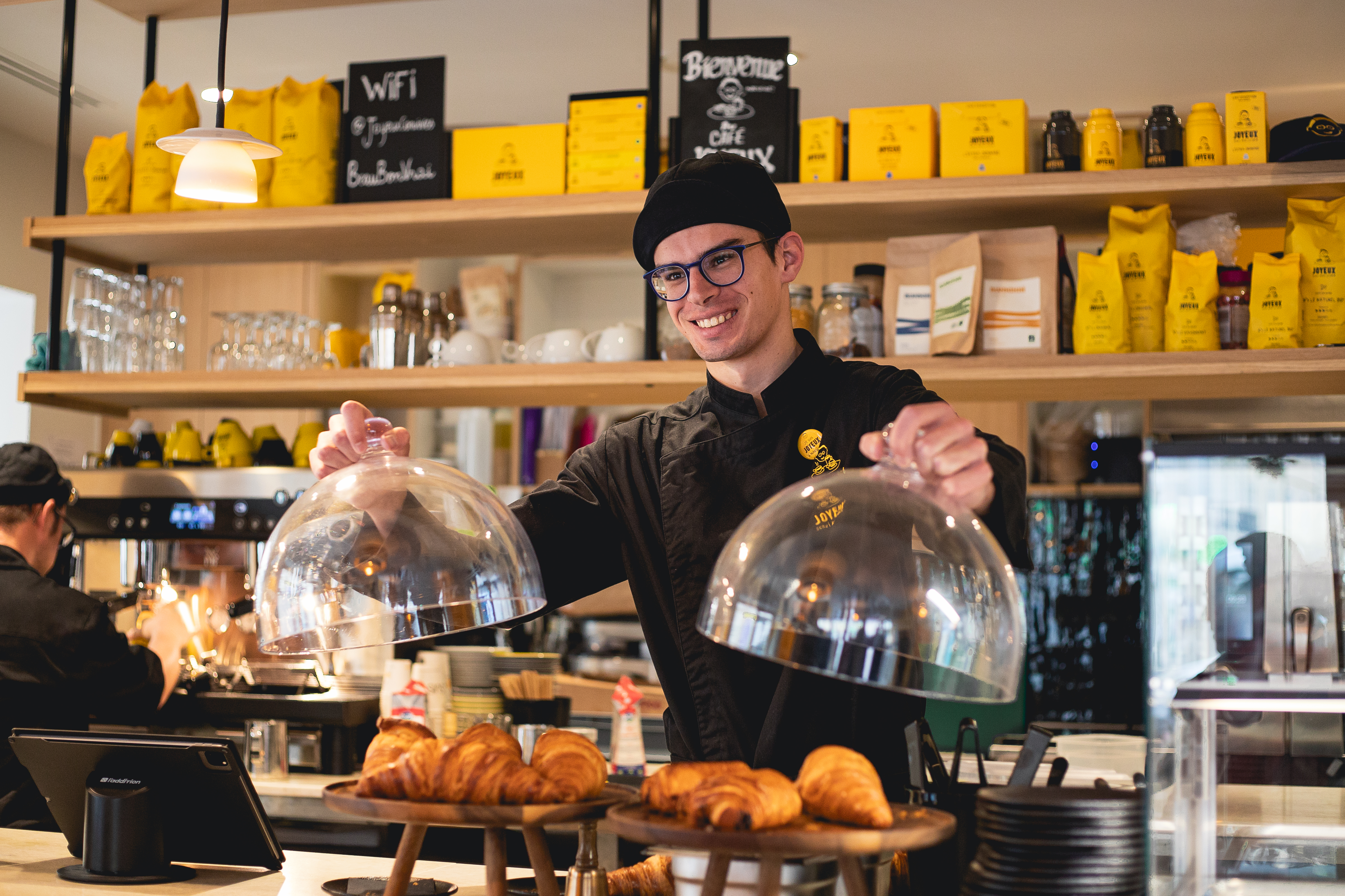 équipier au comptoir qui présente des produits