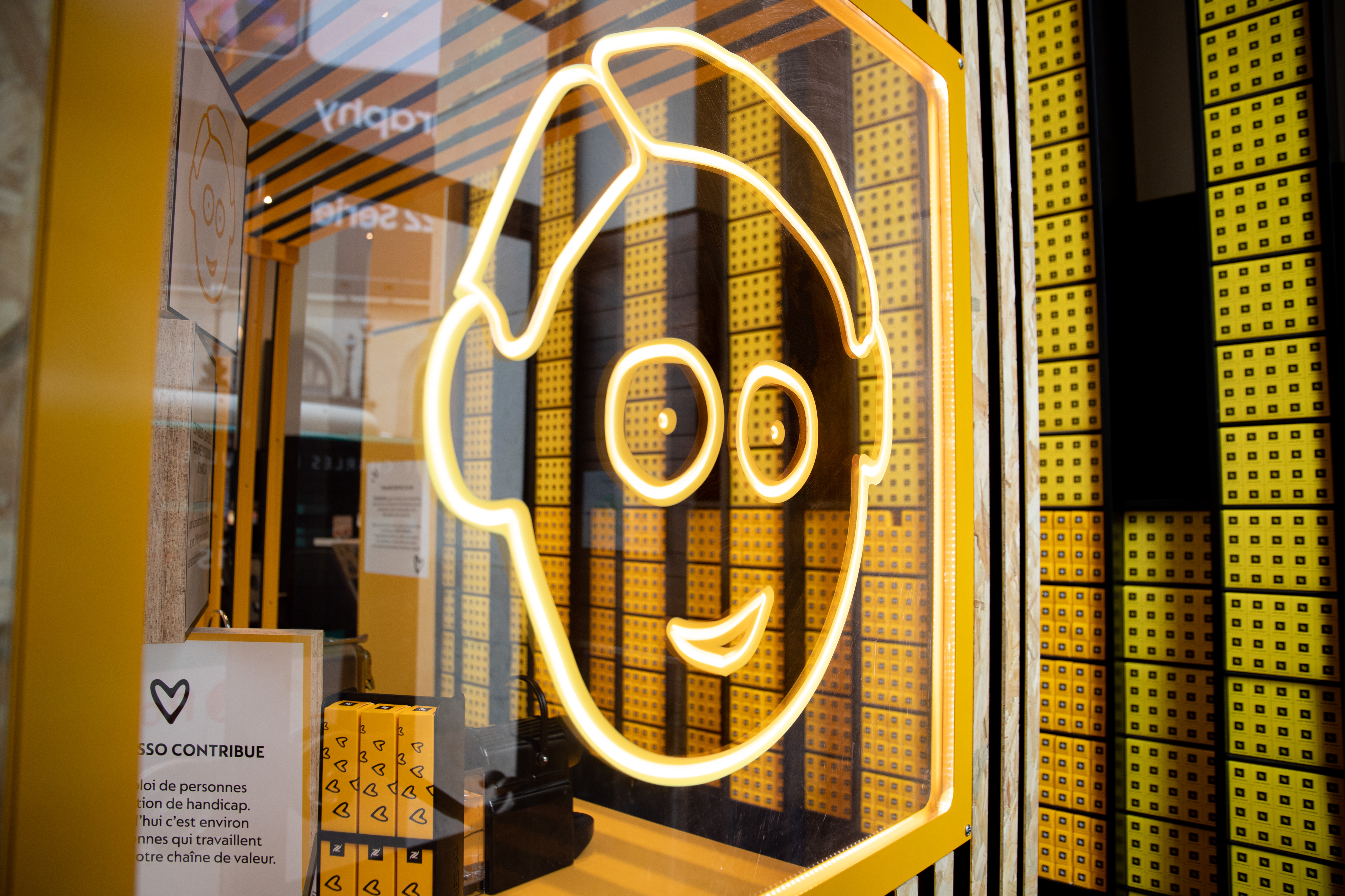 Logo Théo Café Joyeux avec capsules Nespresso en fond